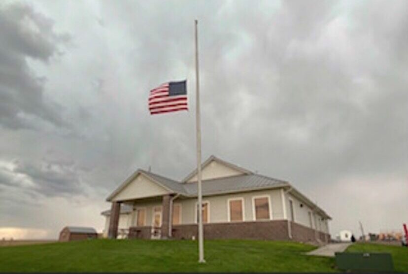 American flag in front of an office is displayed at half-staff